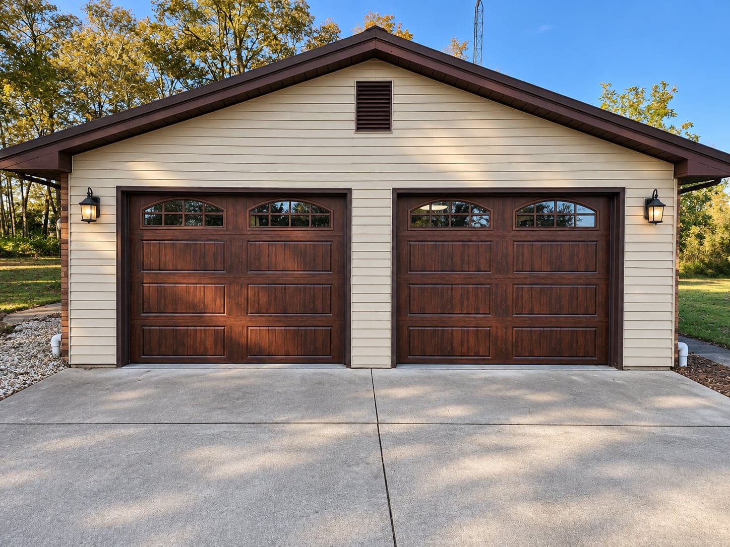 A detached garage with two woodgrain doors with windows