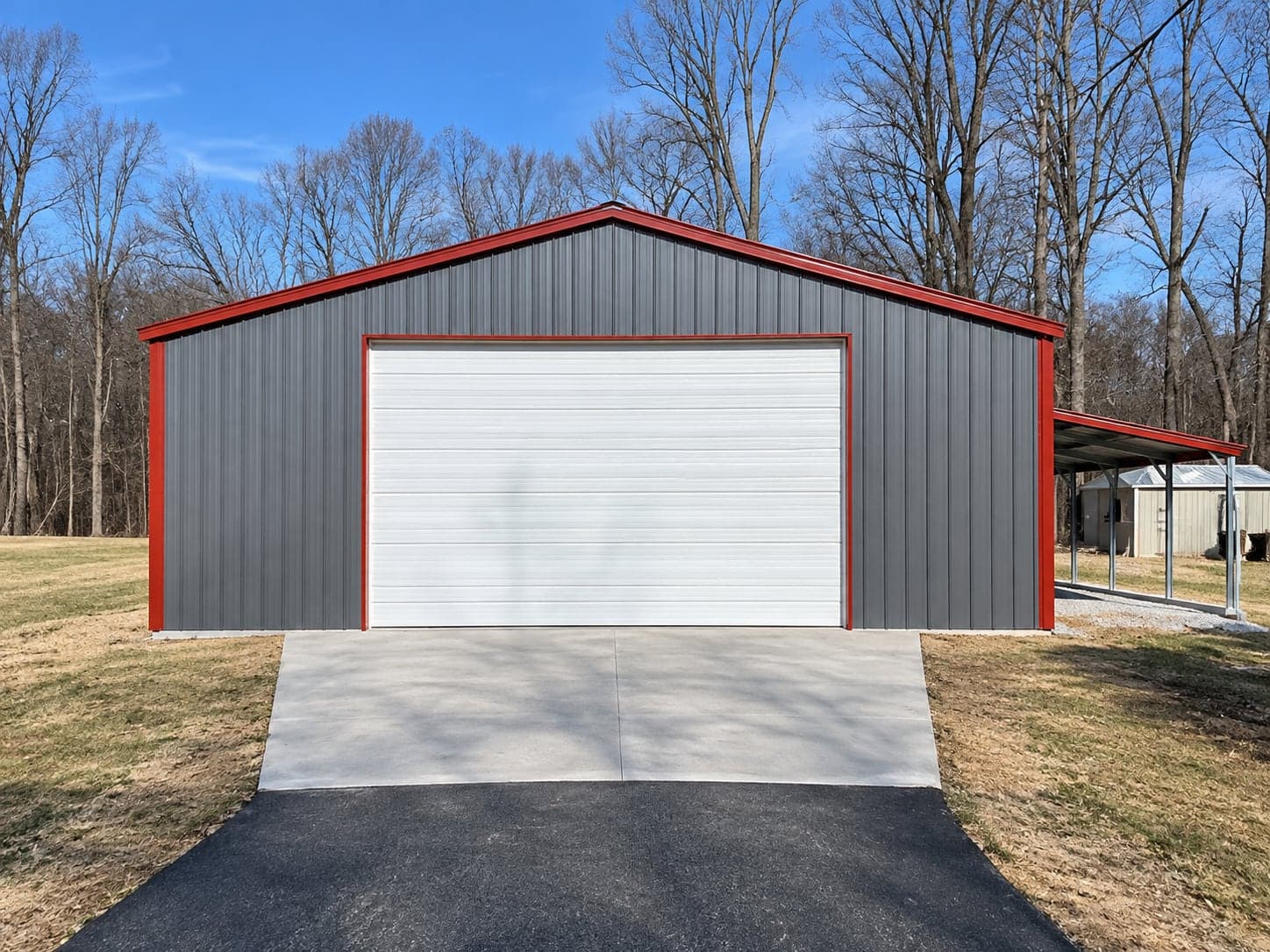 A tall white overhead door on a gray steel building with red trim